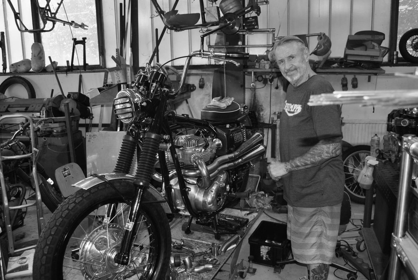 Ein Motorrad in unserer Werkstatt - Mann steht vor einem Motorrad bei einer Reparatur